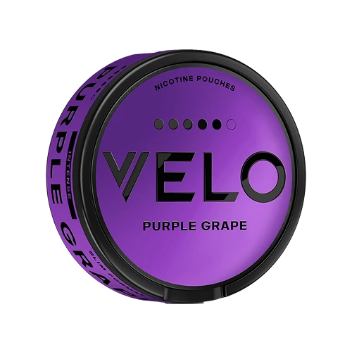 A round can of VELO Purple Grape nicotine pouches, featuring a metallic purple lid with black branding and a black rim, set against a plain white background.